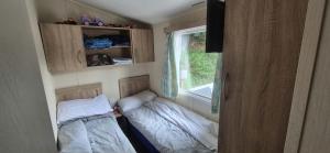 a small room with two beds and a window at Heatherview Willerby in Bishop Auckland