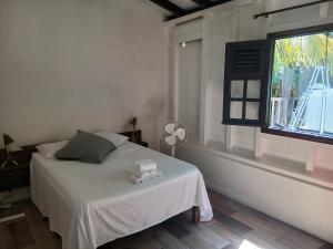 a bedroom with a white bed and a window at villa timokei piscine et jacuzzi in Fond Saint-Jacques +72 photos