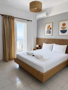 a bedroom with a large bed with a large window at Harmonia Himara in Himare