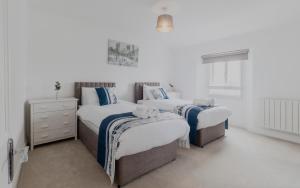 a bedroom with two twin beds and a dresser at Executive 2BR Business & Contractor Stay in Weston-super-Mare
