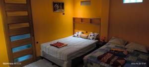 a small bedroom with two beds and a closet at La Casa Amarilla in Sololá