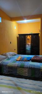 a bedroom with two beds and a mirror on the wall at La Casa Amarilla in Sololá