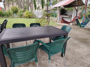a wooden table with green chairs and a playground at Giomari in Shekhvetili