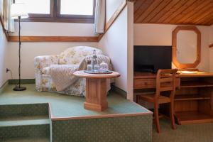 a living room with a table and a chair at Meublè Siesle in Sauris