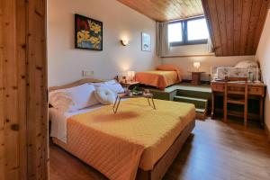 a bedroom with two beds and a table in it at Meublè Siesle in Sauris