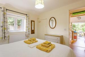 a bedroom with two yellow pillows on a white bed at 1 Bed in Snape oc-9tts in Snape