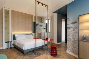 a bedroom with a white bed and a red table at B&B HOTEL Milano Duomo Velasca in Milan