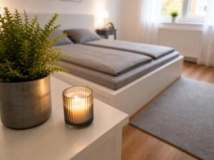 a bedroom with a bed with a candle on a table at Pulheim Living 5 in Pulheim +4 photos