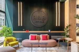 a seating area with a couch and two chairs at B&B HOTEL Milano Duomo Velasca in Milan