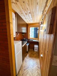 a small kitchen with a white refrigerator and a window at VILA PAVLOVIC in Kopaonik