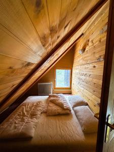 a bed in a room with a wooden wall at VILA PAVLOVIC in Kopaonik