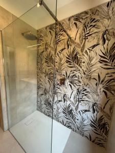 a shower with a black and white wallpaper at Casa vacanza Giardinolago in Sale Marasino