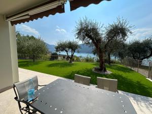a table and chairs on a patio with a view at Casa vacanza Giardinolago in Sale Marasino