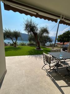 a patio with a table and a view of the ocean at Casa vacanza Giardinolago in Sale Marasino