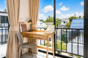 an office with a desk and a balcony with windows at Beachside Villa in Ko Phangan