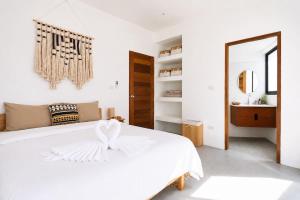 a white bedroom with a white bed and a mirror at Beachside Villa in Ko Phangan +7 photos