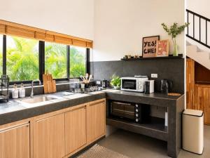 a kitchen with a sink and a microwave at Beachside Villa in Ko Phangan
