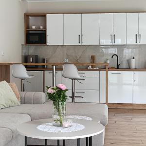 a living room with a vase of flowers on a table at Apartamenty 40 in Ciechocinek