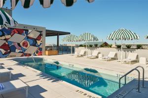 a pool at a resort with chairs and a mosaic wall at Arlo Washington DC in Washington, D.C.