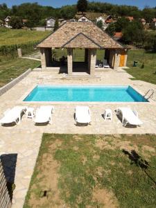 a swimming pool with lounge chairs and a gazebo at Čajića avlija pool house in Obrenovac