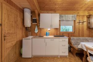 a kitchen with white cabinets and a sink at 3 Rivers Beehive cabin on a farm in Radovljica