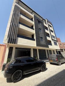 a black car parked in front of a building at Irmouli in Sétif