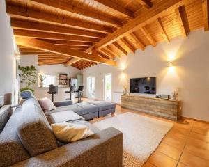 a living room with a couch and a tv at Seashore Escape by Lisbeyond in Aljezur