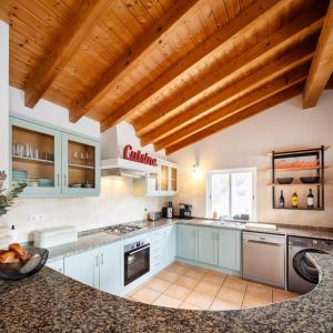 a kitchen with white cabinets and a wooden ceiling at Seashore Escape by Lisbeyond in Aljezur