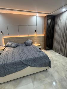 a bedroom with a large bed and two pillows at Irmouli in Sétif