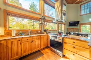 a kitchen with wooden cabinets and a large window at Beautiful Home, Views, Near Whiteface, Lake Placid in Wilmington