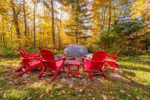 a group of four red chairs around a fire pit at Beautiful Home, Views, Near Whiteface, Lake Placid in Wilmington