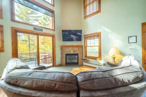 a living room with a leather couch and a fireplace at Beautiful Home, Views, Near Whiteface, Lake Placid in Wilmington +56 photos