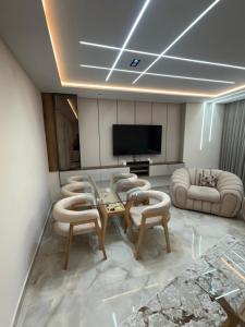 a living room with a table and chairs and a television at Irmouli in Sétif