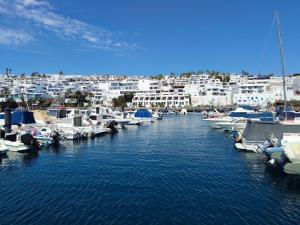 a group of boats docked in a harbor with buildings at Lindas Vistas in Tías