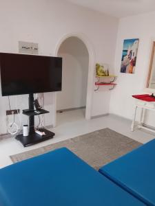 a living room with a flat screen tv on a stand at Rent Vacancy Arcoiris in Tías