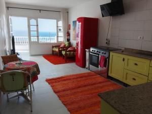 a kitchen with a red refrigerator and a living room at Rent Vacancy Arcoiris in Tías