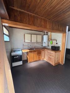 a kitchen with wooden cabinets and a stove at Magnolia Tempo in Esquel