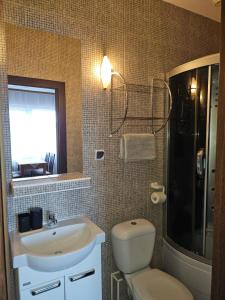 ein Badezimmer mit Waschbecken, Toilette und Fenster in der Unterkunft Aga Mielenko Pokoje i Apartamenty in Mielenko + 28 Fotos
