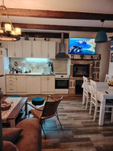 a kitchen and dining room with a tv on the wall at Etno house HAPPY VILLAGE in Cetinje