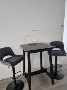 a black table with two chairs and a lamp on it at Apartment Affengrün in Weyhausen