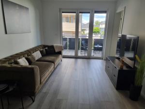 a living room with a couch and a sliding glass door at Apartment Affengrün in Weyhausen