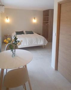 a bedroom with a bed and a table and chairs at L'Arcadia Chambres d'hôtes près de Vaison la Romaine et Mont Ventoux à Crestet in Crestet