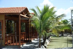 a house with palm trees in front of it at Đức Hòa homestay in Ấp Thố Mố (1)