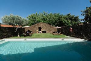 a large swimming pool in front of a stone house at Morgadio da Calcada Douro Wine&Tourism in Pinhão