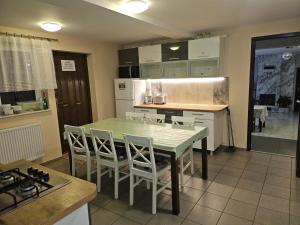 eine Küche mit Tisch, Stühlen und Kühlschrank in der Unterkunft Aga Mielenko Pokoje i Apartamenty in Mielenko
