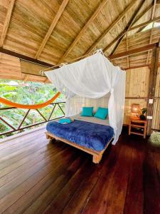 a bed in a room with a mosquito net at Casa Prana Nuquí in Nuquí