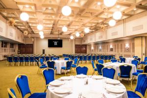 a banquet hall with tables and chairs and a projection screen at Grand Hotel Traian in Iaşi