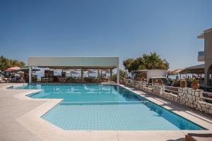 a large swimming pool with a pavilion next to a building at Erato Beach Hotel Adults Only by Smile Hotels in Platanias