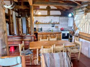 a kitchen with a wooden table and chairs at El Rancho in Villa Giardino +3 photos
