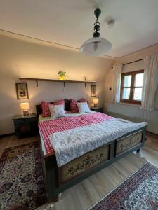 ein Schlafzimmer mit einem Bett mit einer rot-weißen Bettdecke in der Unterkunft Omas Paradies in Größing